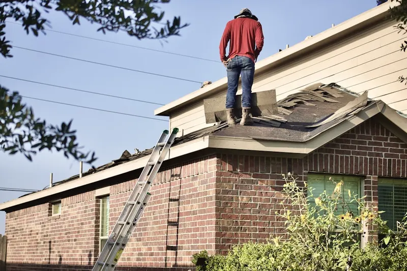 Professional roofer working on a residential roof in Head of the Harbor